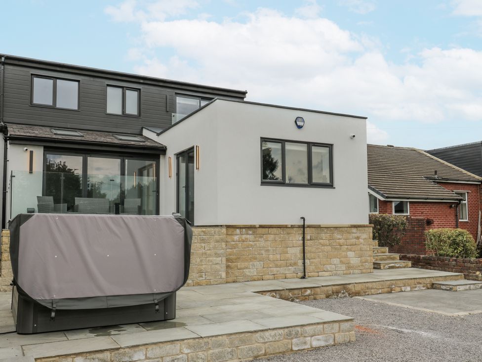 An outdoor area with a hot tub and seating at Ellis House in Huddersfield