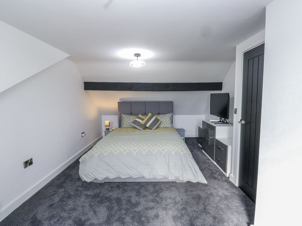 A bedroom with a bed and television at Ellis House in Huddersfield