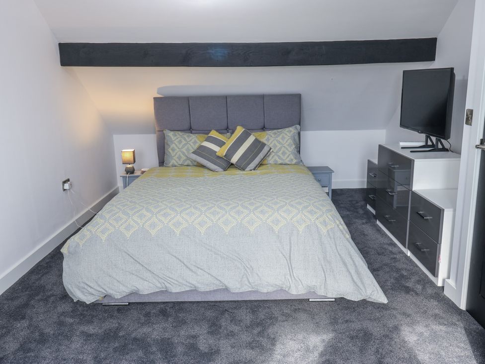 A bedroom with a bed, lamp, and television at Ellis House in Huddersfield