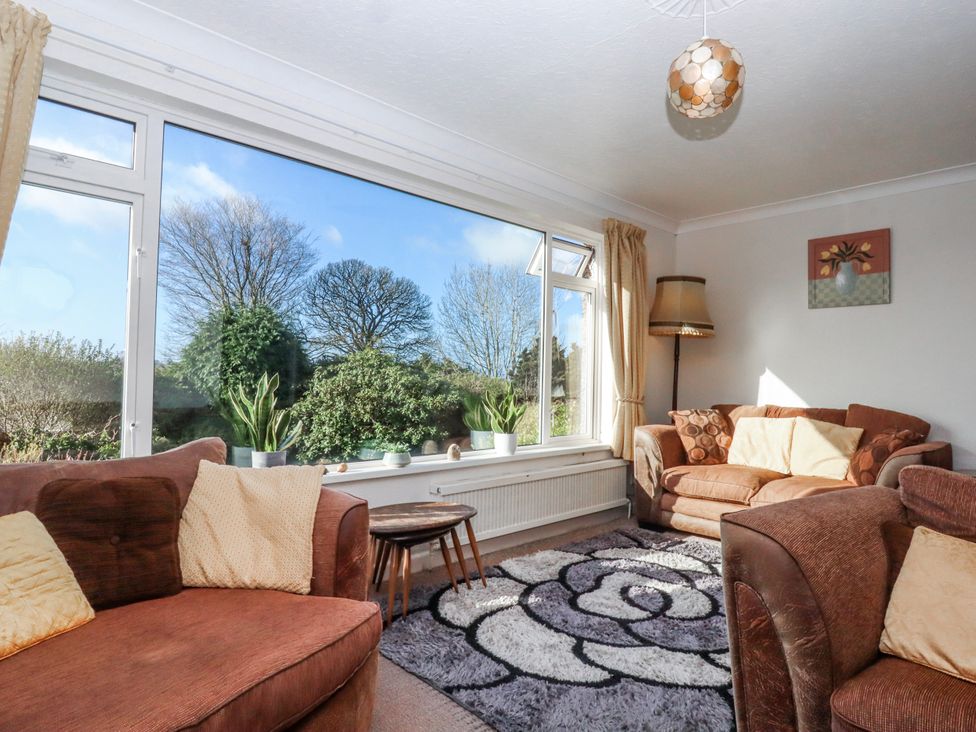 A living room with sofas and a view of trees at 7 Erme Drive in Ivybridge