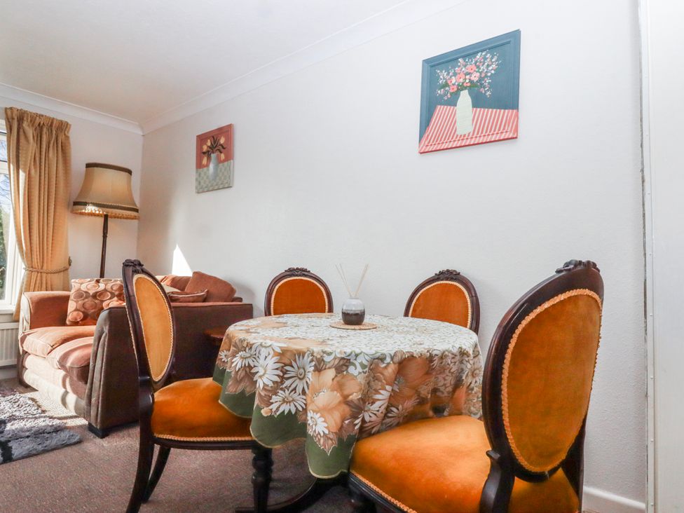 A living room with a table and chairs at 7 Erme Drive in Ivybridge