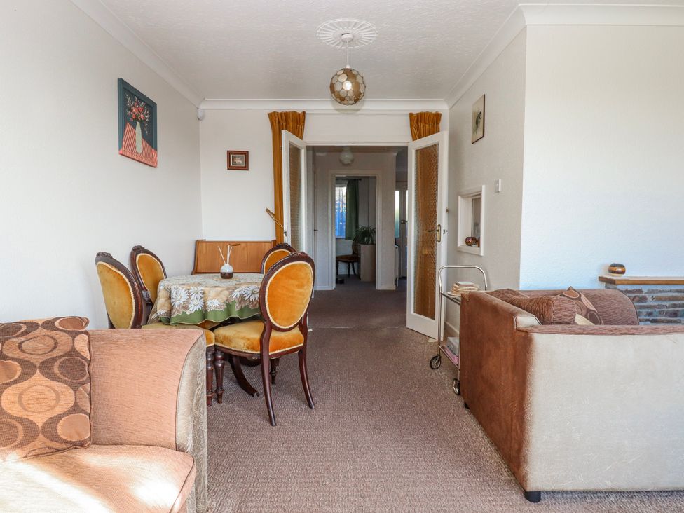 A living room with a table and chairs at 7 Erme Drive in Ivybridge