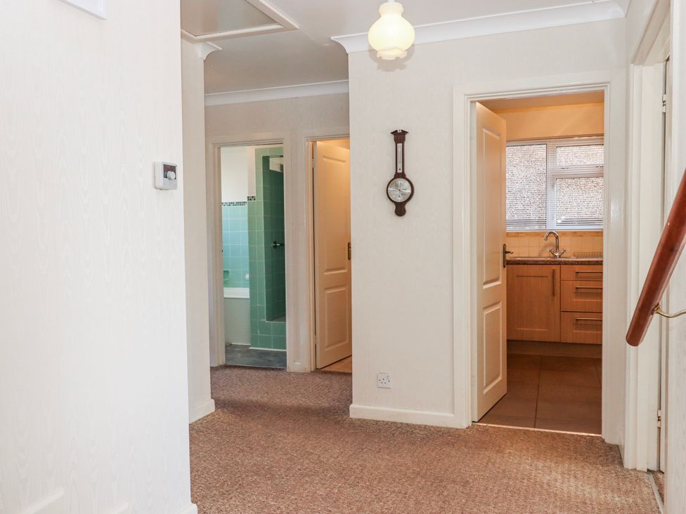 A hallway with doors leading to kitchen and bathroom at 7 Erme Drive in Ivybridge