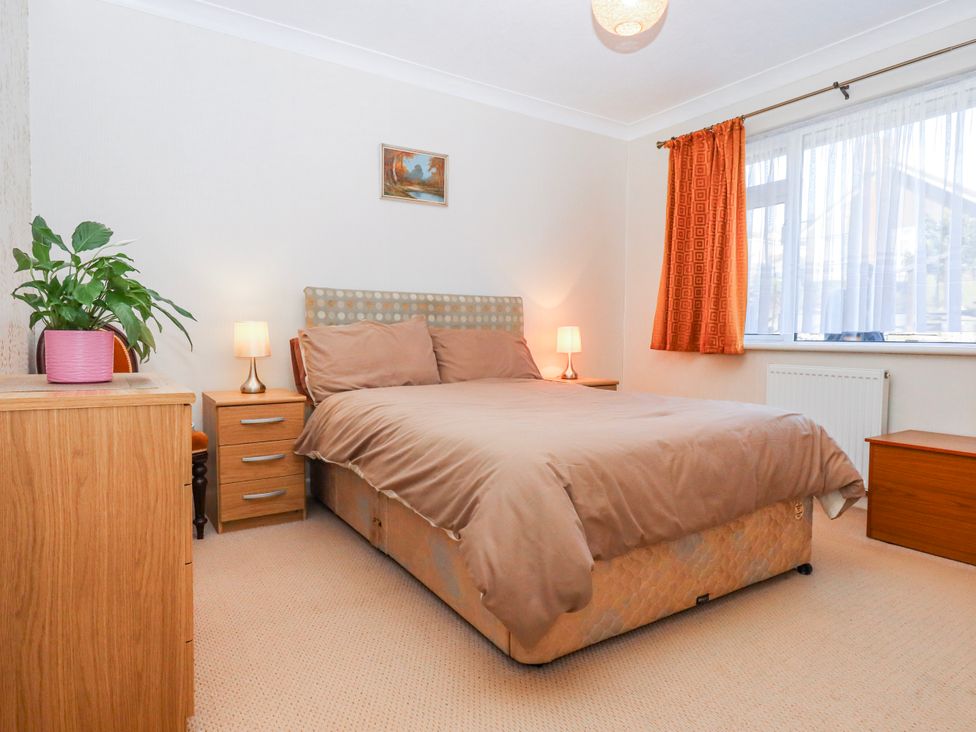 A bedroom with a bed and side table at 7 Erme Drive in Ivybridge
