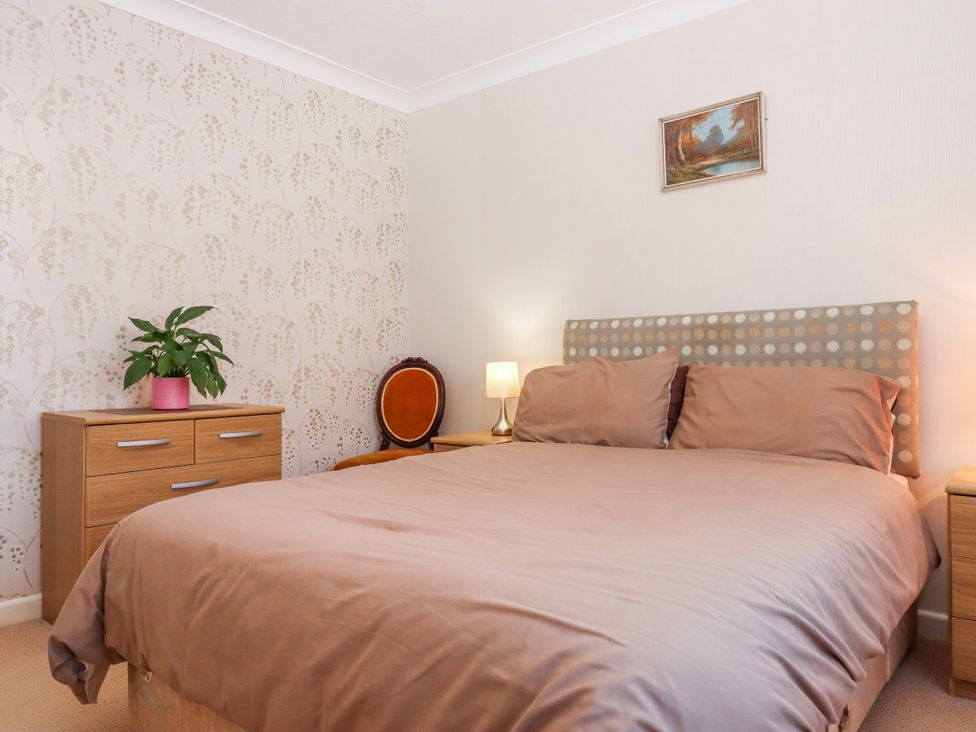 A bedroom with a bed and bedside tables at 7 Erme Drive in Ivybridge