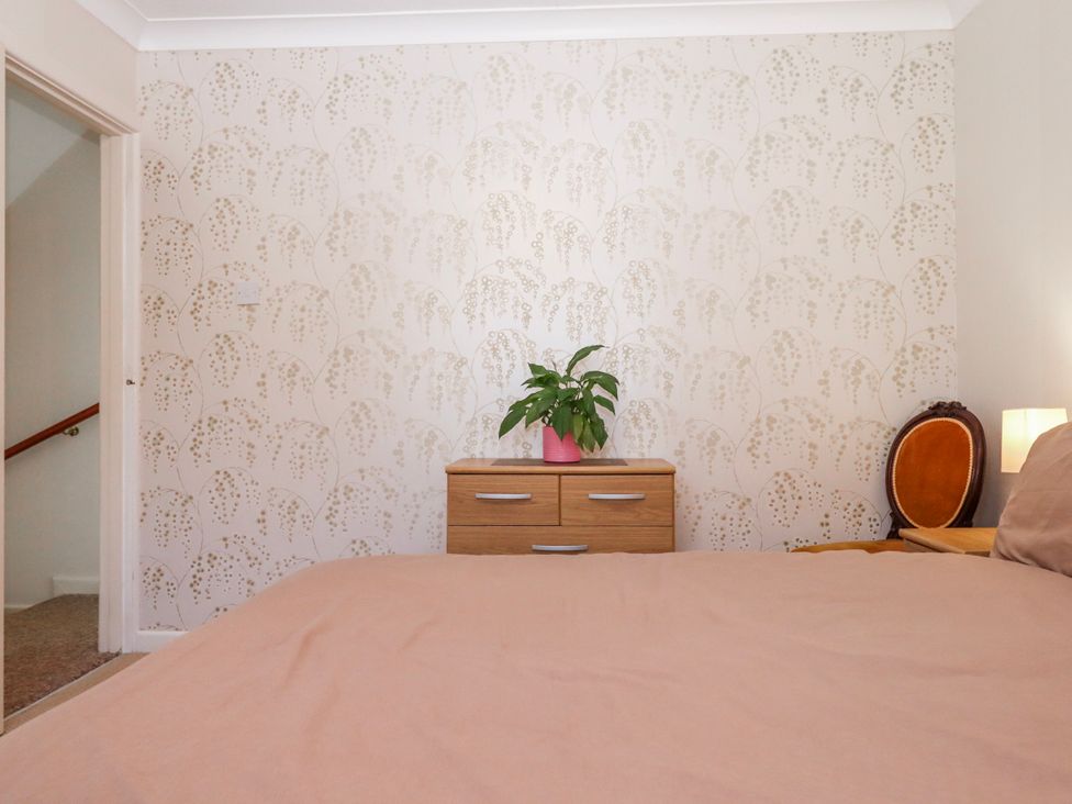 A bedroom with a bed and plant on a drawer unit at 7 Erme Drive in Ivybridge