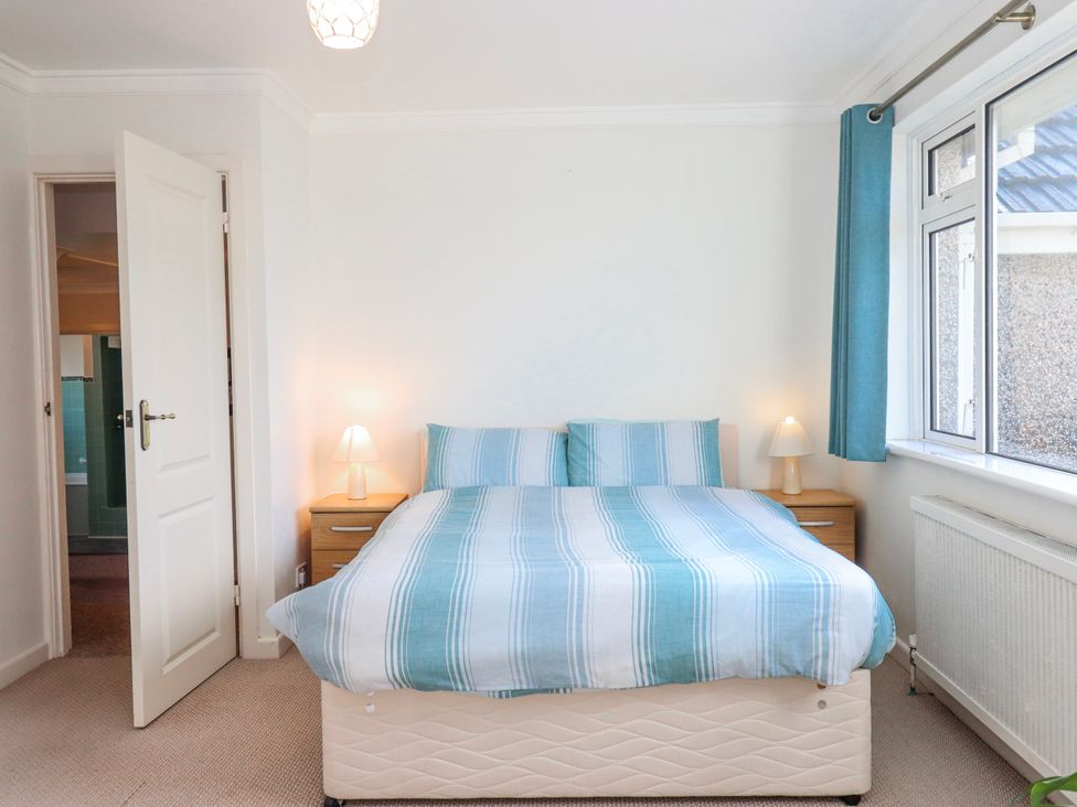 A bedroom with a bed and bedside tables at 7 Erme Drive in Ivybridge