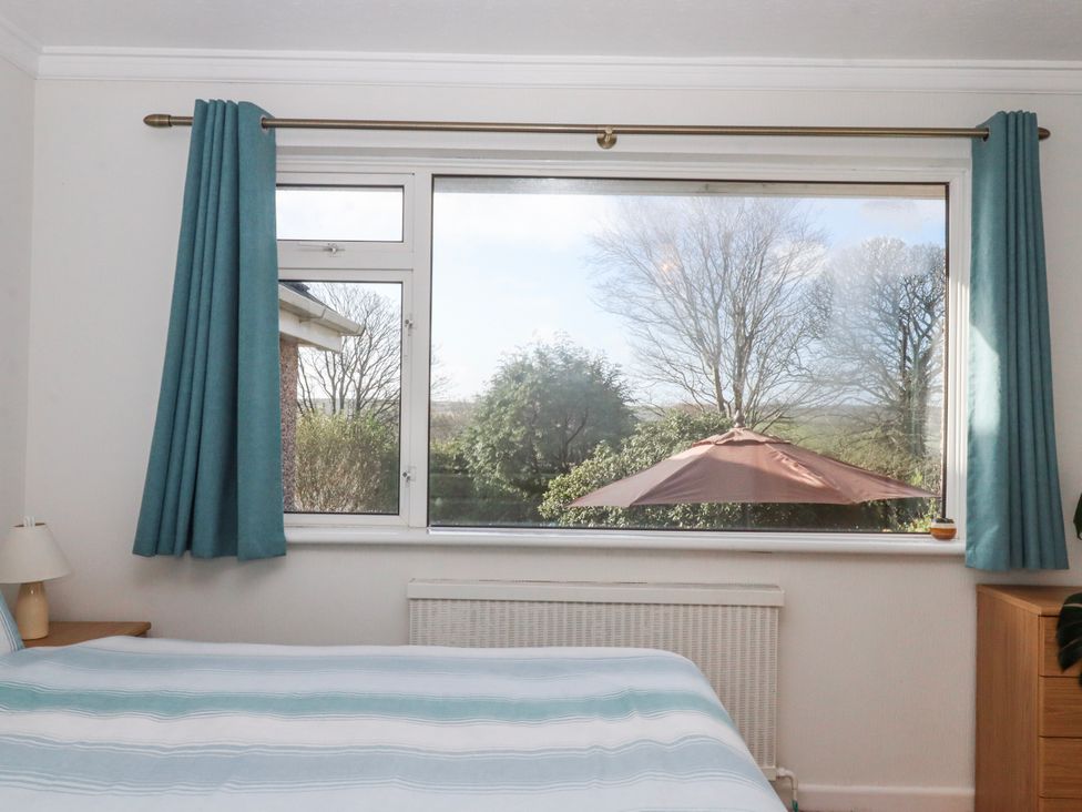 A bedroom with a window and bed at 7 Erme Drive in Ivybridge