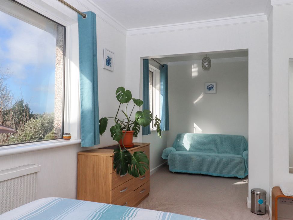 A bedroom with a window and a couch at 7 Erme Drive in Ivybridge