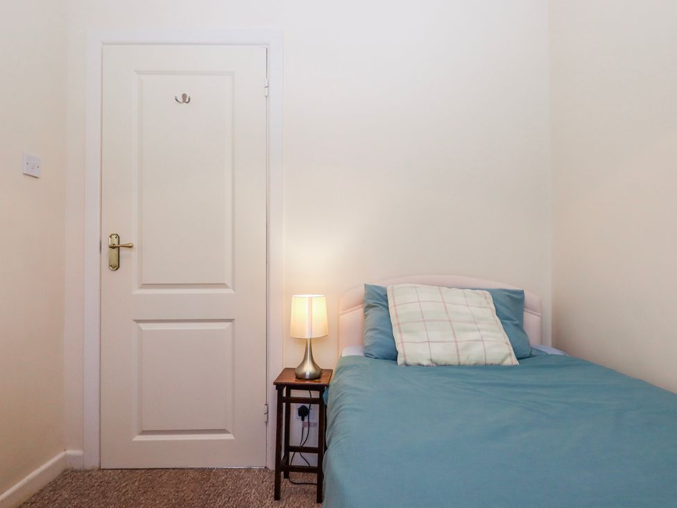 A bedroom with a bed and a lamp at 7 Erme Drive, Ivybridge