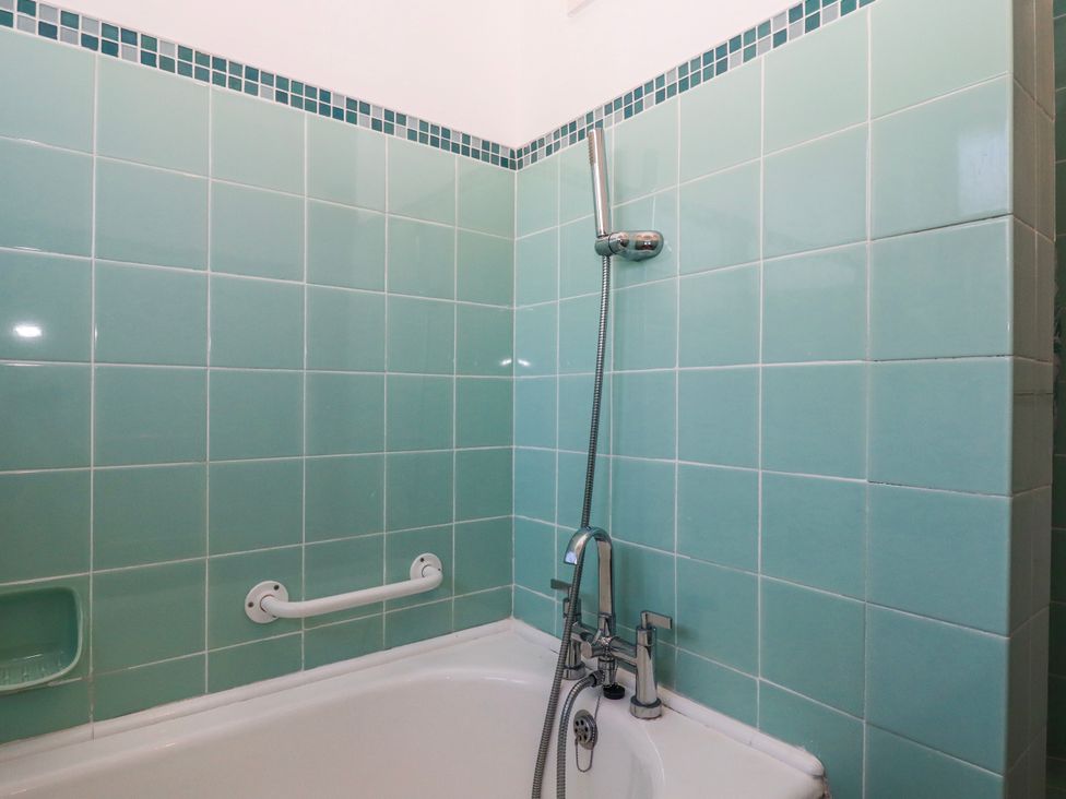 A bathroom with a bathtub and showerhead at 7 Erme Drive in Ivybridge
