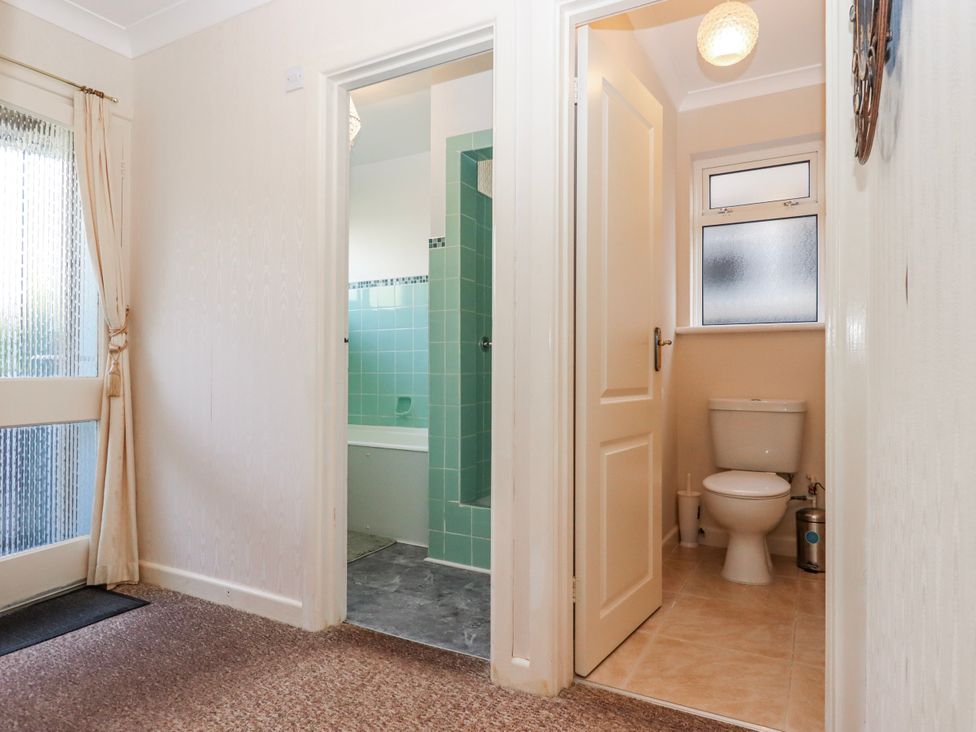 A bathroom with a toilet and bath at 7 Erme Drive in Ivybridge