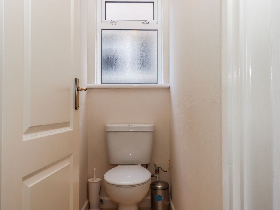 A bathroom with a toilet and window at 7 Erme Drive in Ivybridge