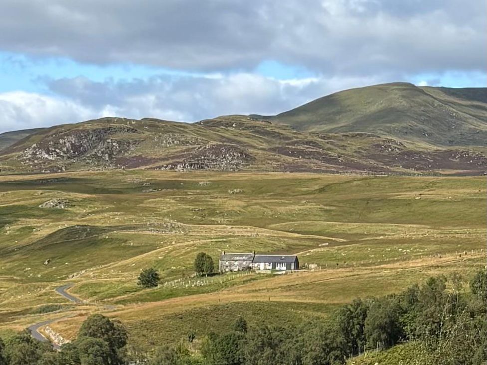 A house situated in a landscape with mountains and fields at The Crannach in Kirkmichael, Perth And Kinross