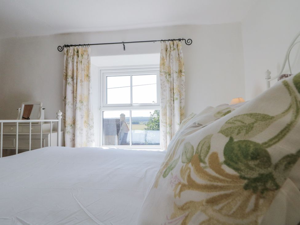 A bedroom with a bed and window at Honeysuckle Cottage in York