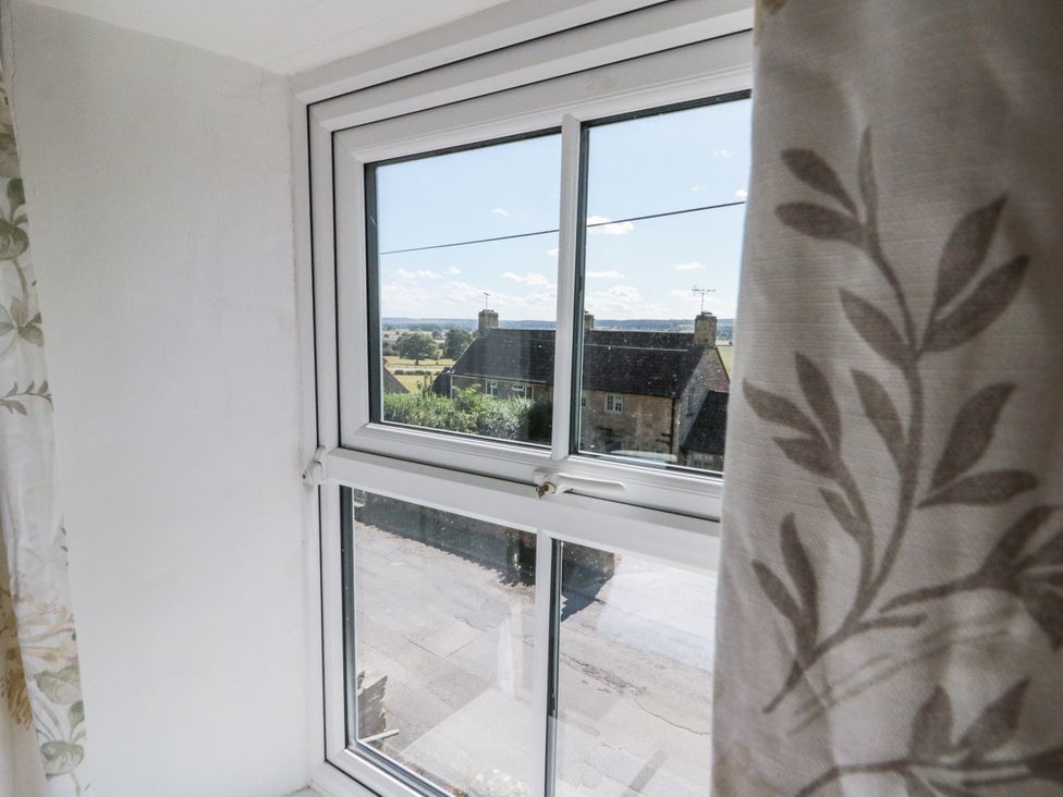 A window view showing houses and a street at Honeysuckle Cottage in York