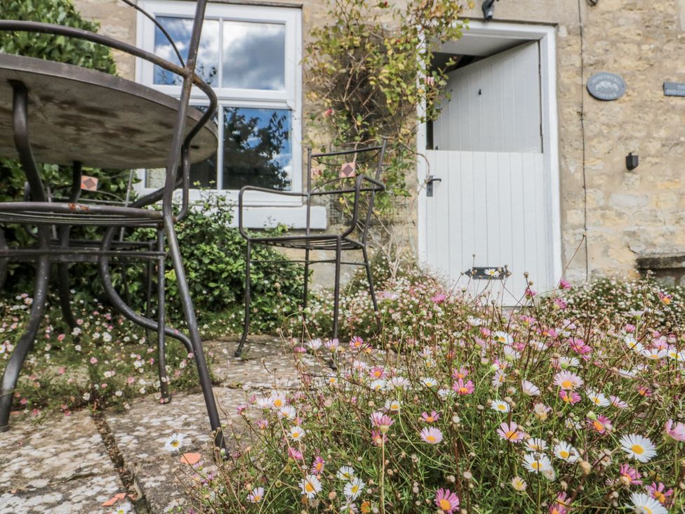 A garden with a table and chair at Honeysuckle Cottage in Oswaldkirk near Helmsley