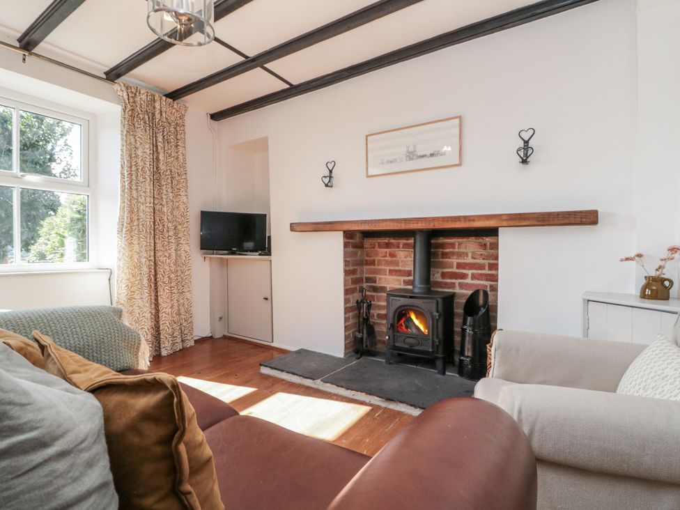 A living room with a fireplace and a television at Honeysuckle Cottage Oswaldkirk near Helmsley