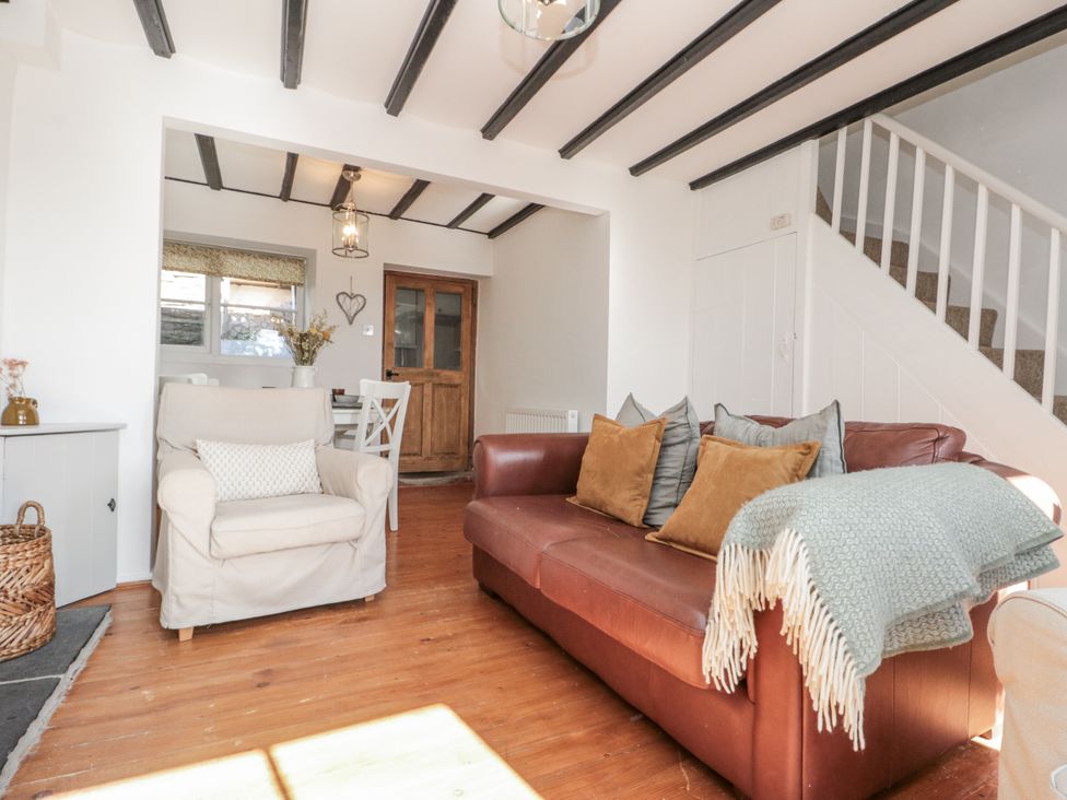 A living room with a sofa and armchair at Honeysuckle Cottage in Oswaldkirk near Helmsley
