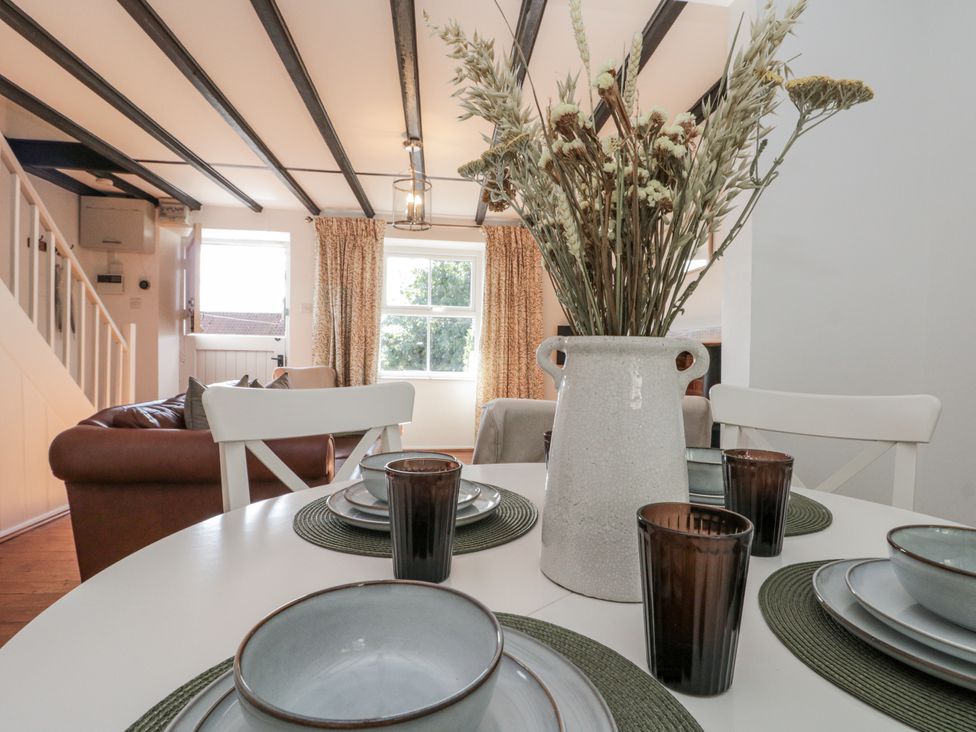 A dining room with a table set for meals at Honeysuckle Cottage Oswaldkirk near Helmsley
