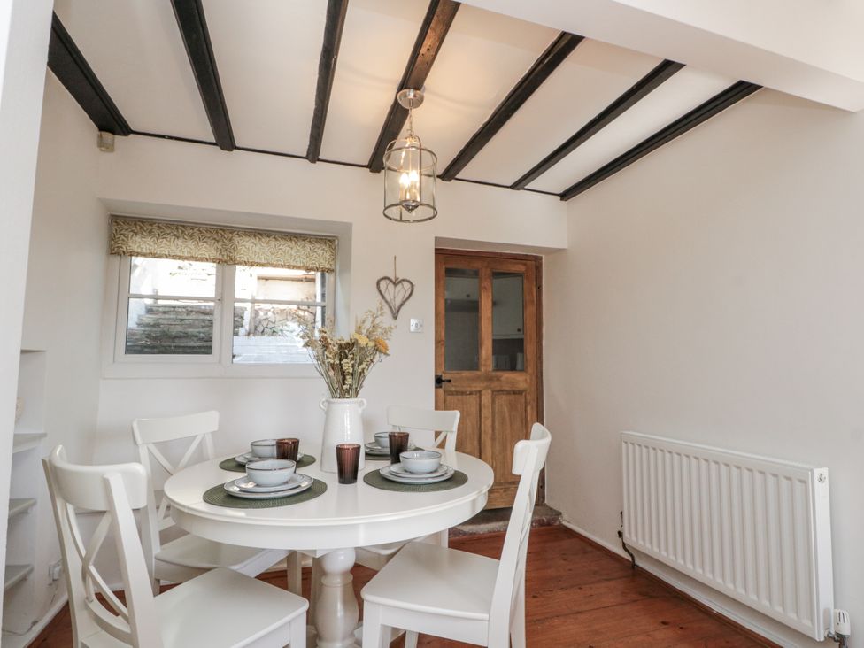 A dining room with a table set for four at Honeysuckle Cottage in Oswaldkirk near Helmsley