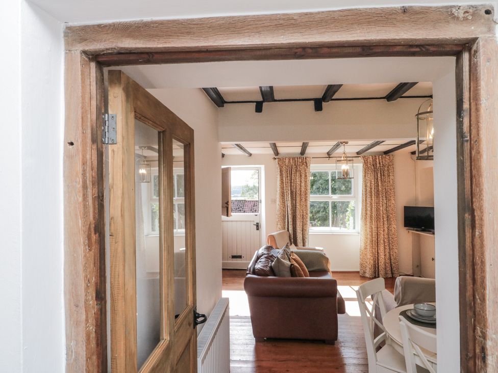A view from a doorway into a living room with a sofa and dining area at Honeysuckle Cottage Oswaldkirk near Helmsley