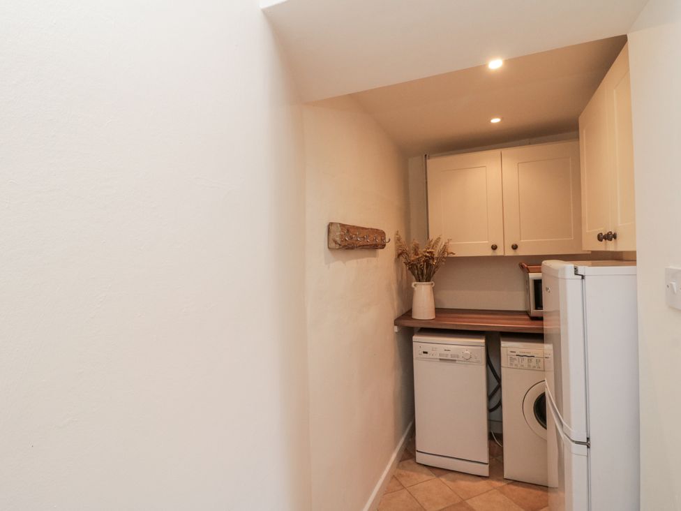 A utility room with appliances and storage at Honeysuckle Cottage near Helmsley