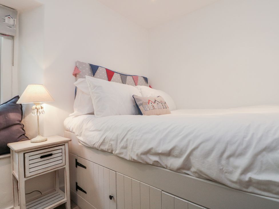 A bedroom with a bed and bedside lamp at Honeysuckle Cottage in Oswaldkirk near Helmsley