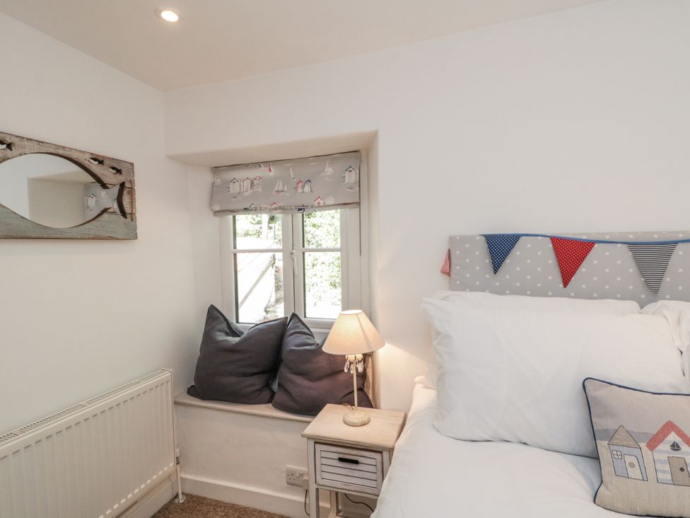 A bedroom with decorative cushions and a lamp at Honeysuckle Cottage in Oswaldkirk near Helmsley