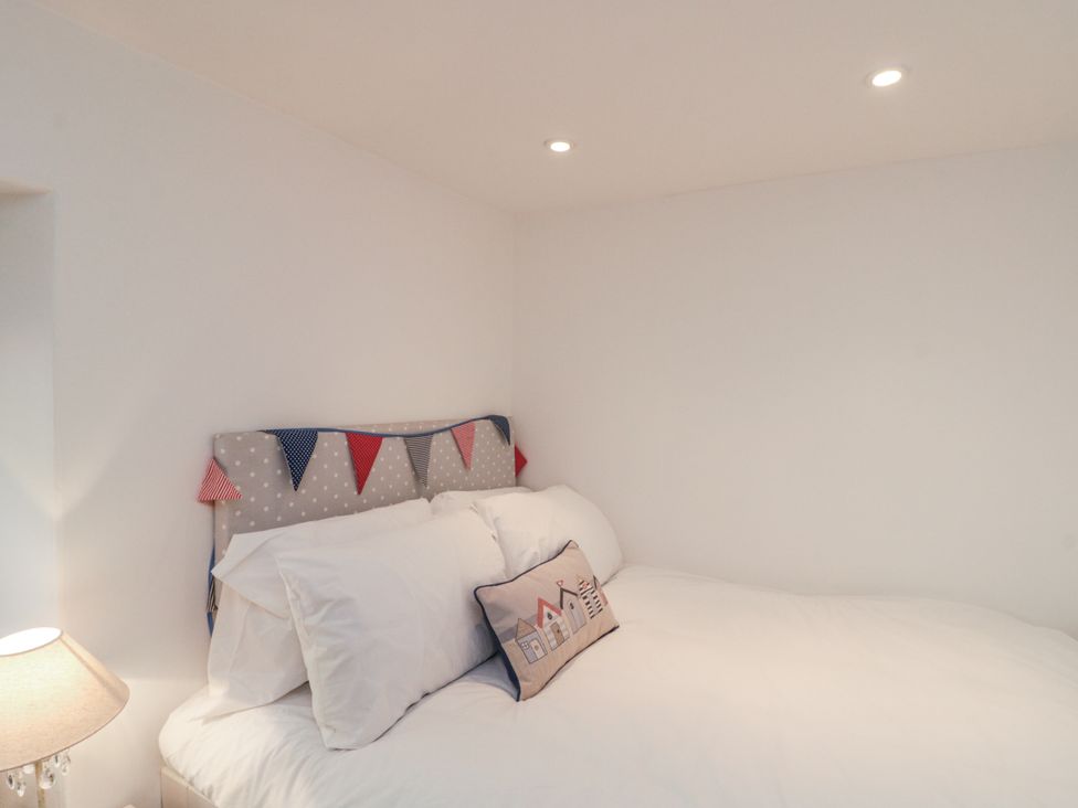 A bedroom with a bed and pillows at Honeysuckle Cottage in Oswaldkirk near Helmsley