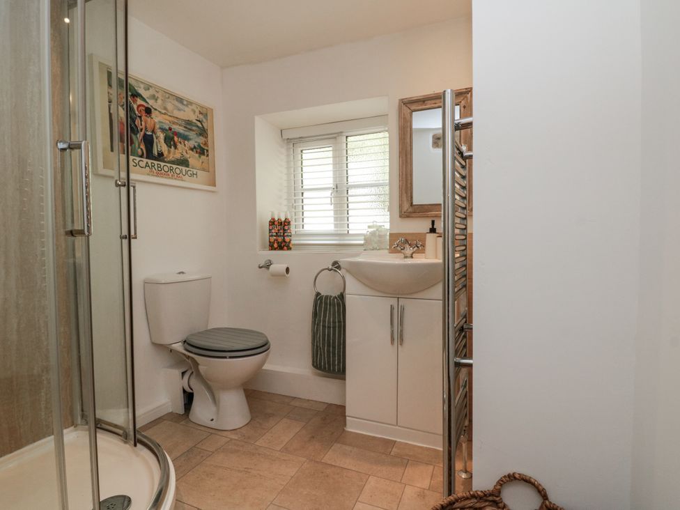 A bathroom with a shower, toilet, and sink at Honeysuckle Cottage Oswaldkirk near Helmsley