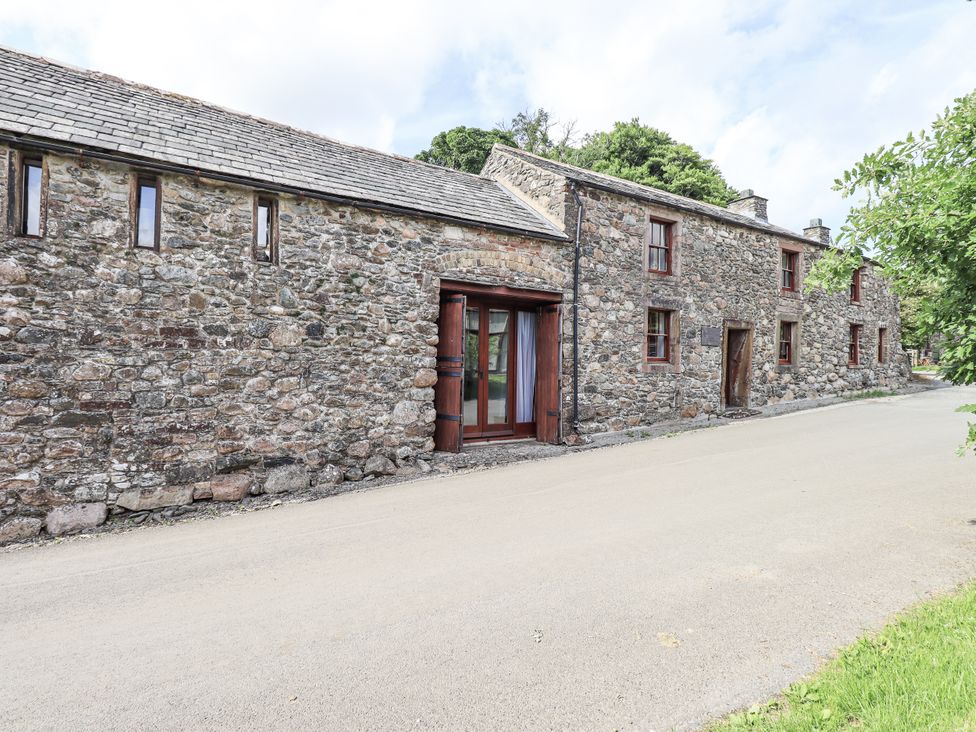 An exterior view of a stone house with a road at Chapel Cottage Ennerdale near Cleator Moor