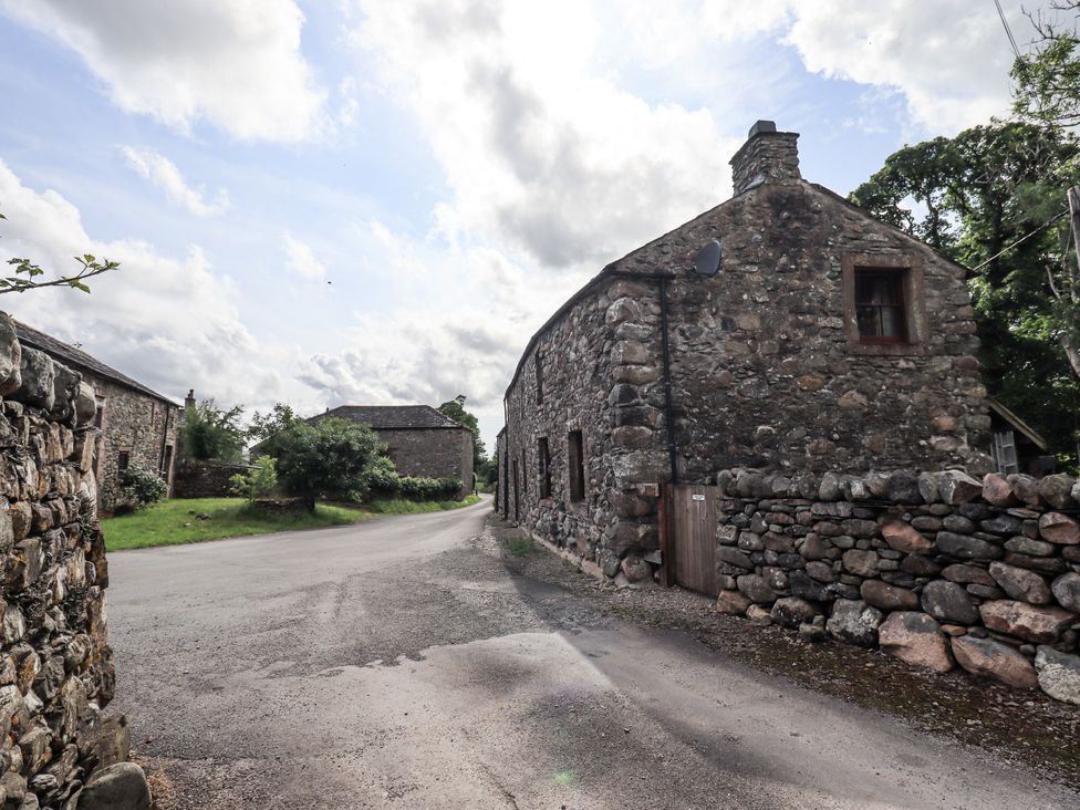 An outdoor view of stone buildings with a road in Ennerdale near Cleator Moor
