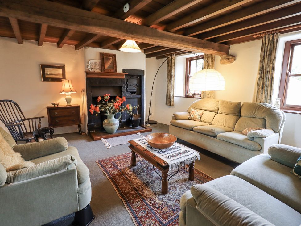 A living room with a sofa and fireplace at Chapel Cottage in Ennerdale near Cleator Moor
