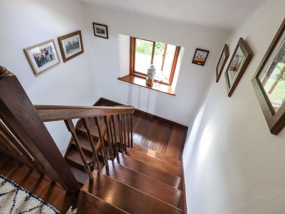 A stairway with a window and photographs at Chapel Cottage in Ennerdale near Cleator Moor