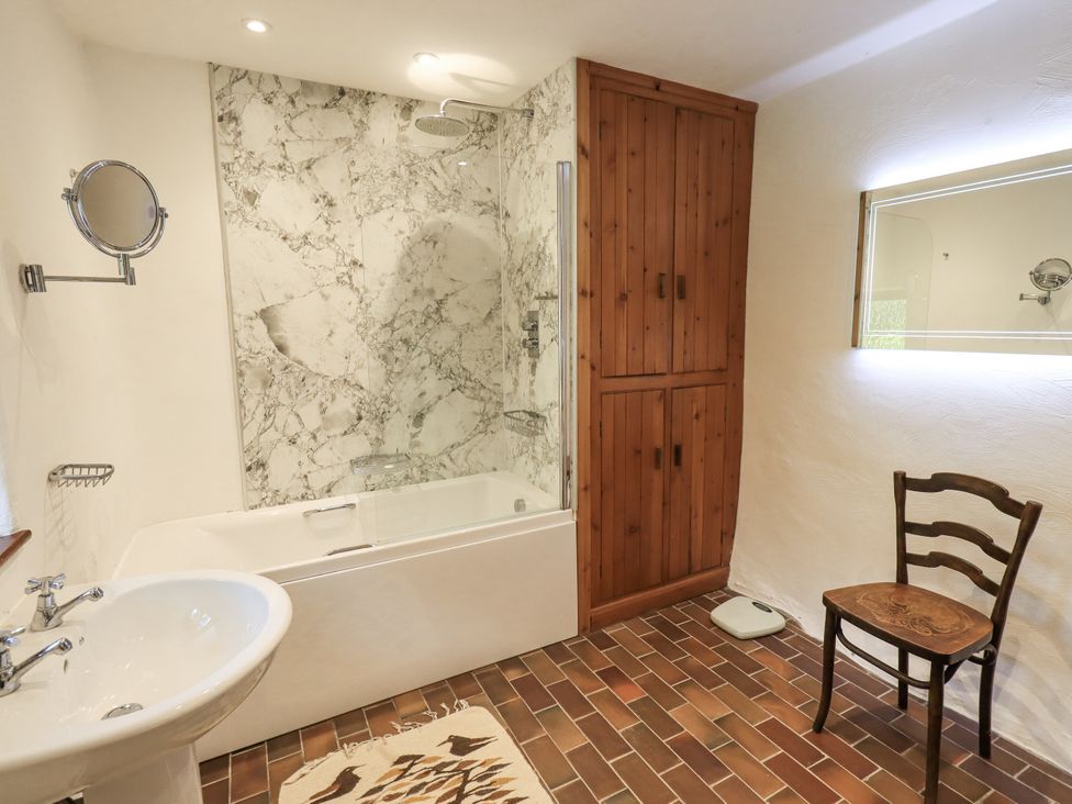 A bathroom with a bathtub and shower at Chapel Cottage in Ennerdale near Cleator Moor