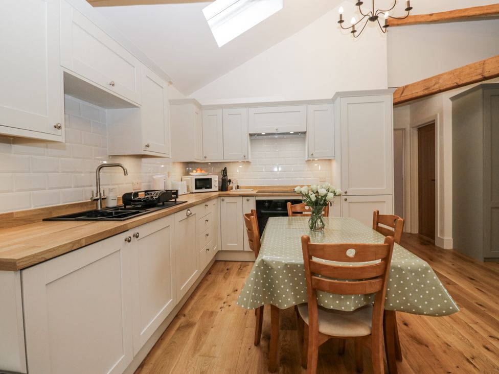 A kitchen with a dining table and chairs at Swift Barn in Wigton