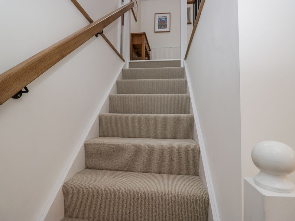 A staircase with a handrail leading upstairs at Swift Barn in Wigton
