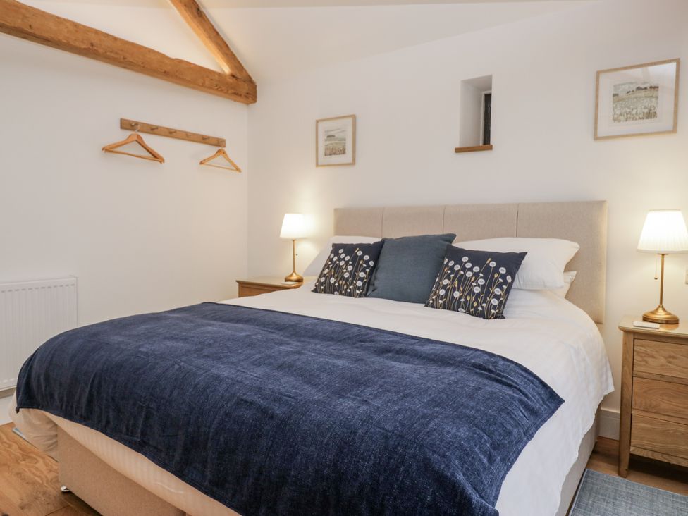 A bedroom with a bed and bedside tables at Swift Barn in Wigton