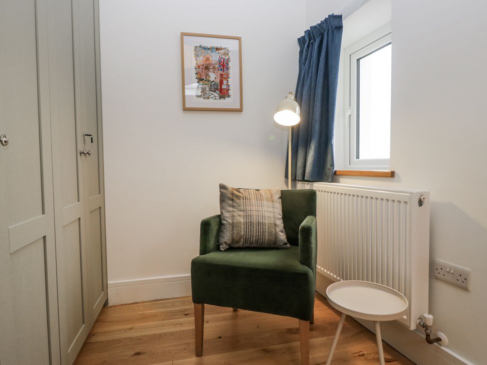 A study area with an armchair and a side table at Swift Barn in Wigton