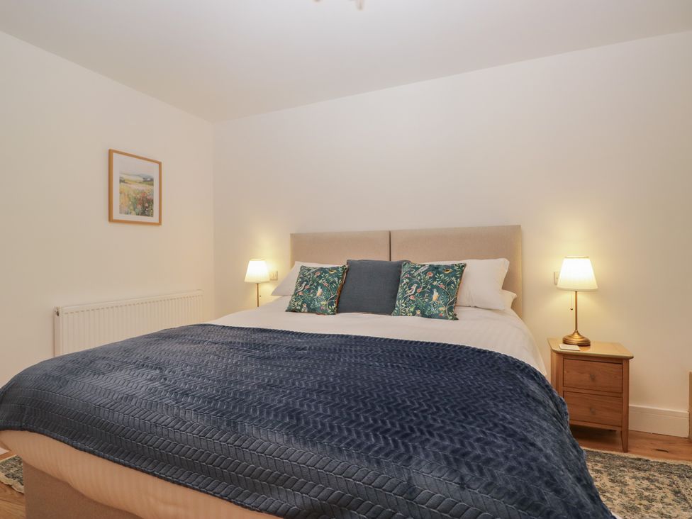 A bedroom with a bed and bedside table at Swift Barn in Gilcrux