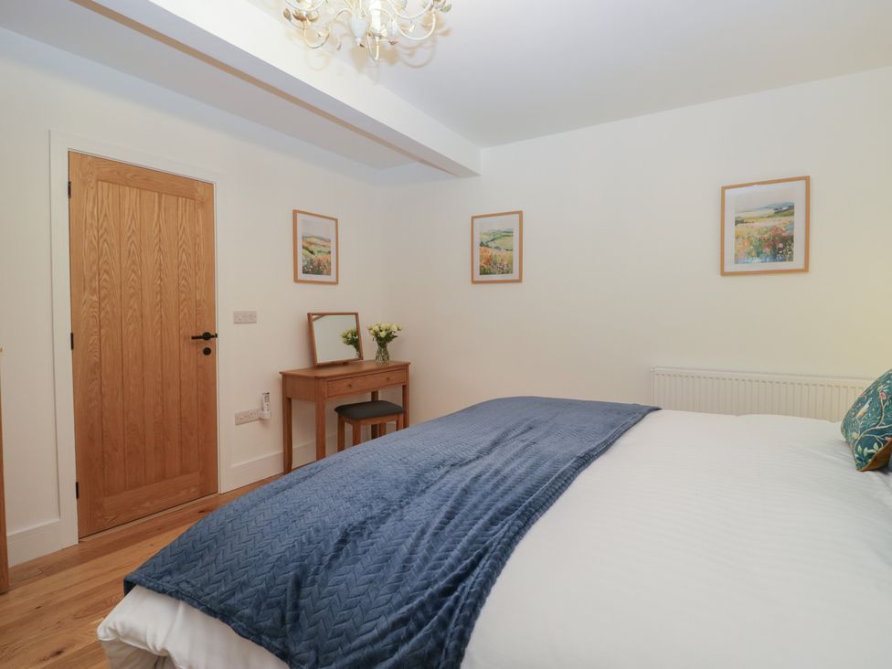 A bedroom with a bed and table at Swift Barn in Gilcrux