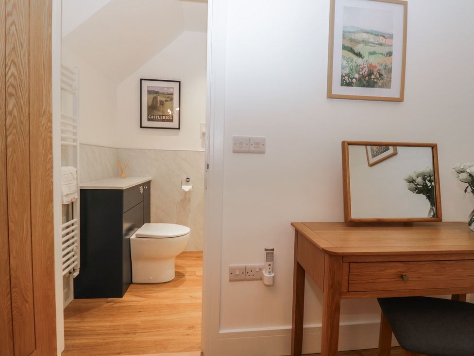 A bathroom with a toilet and vanity at Swift Barn in Gilcrux