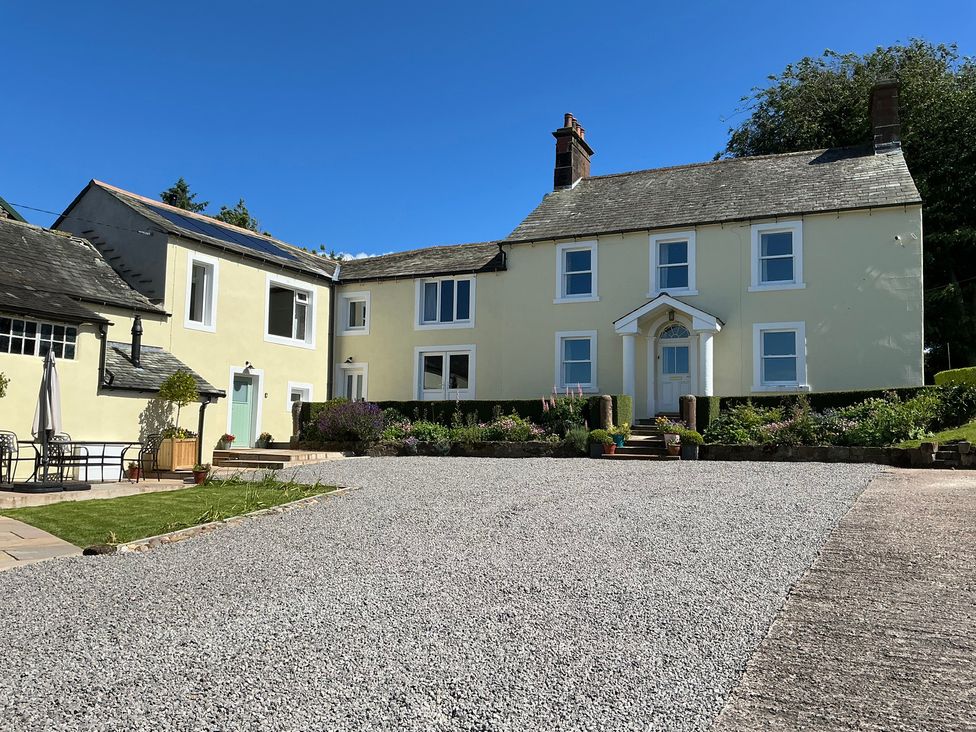 A house with a gravel driveway and garden at Swift Barn in Gilcrux