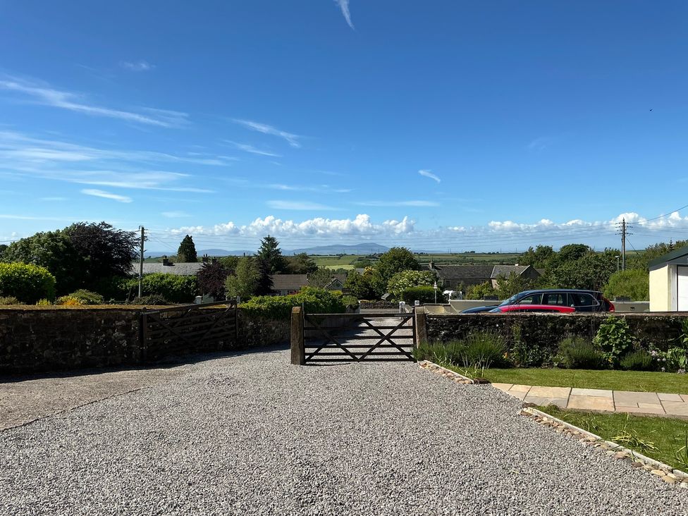 A driveway with a gate and cars at Swift Barn in Gilcrux