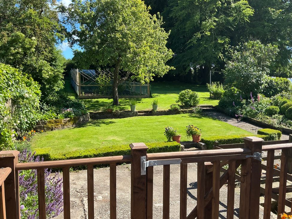 A garden with a lawn and flower pots at Swift Barn in Gilcrux