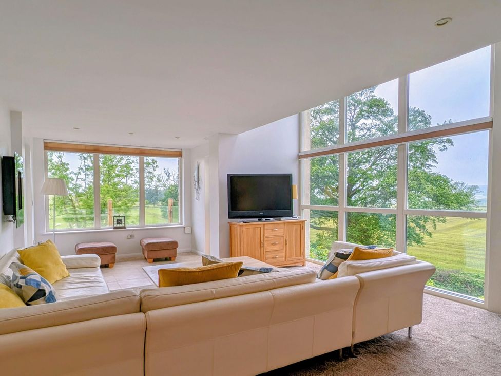 A living room with a television and sofa at High View Meadows in Kirkby Lonsdale