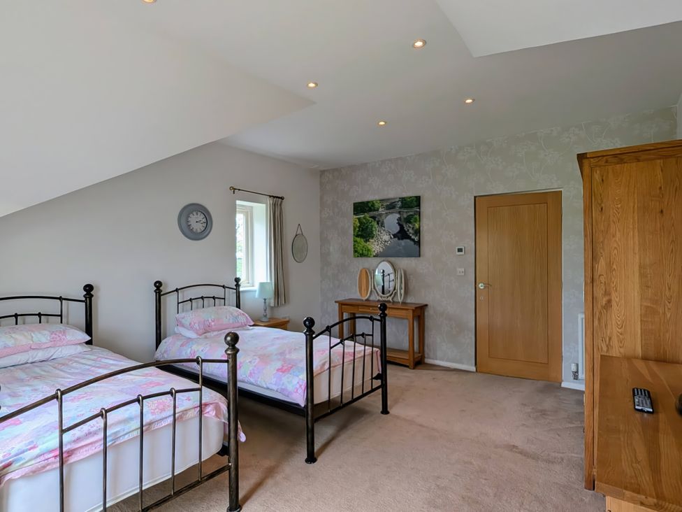 A bedroom with two beds and a mirror at High View Meadows in Kirkby Lonsdale