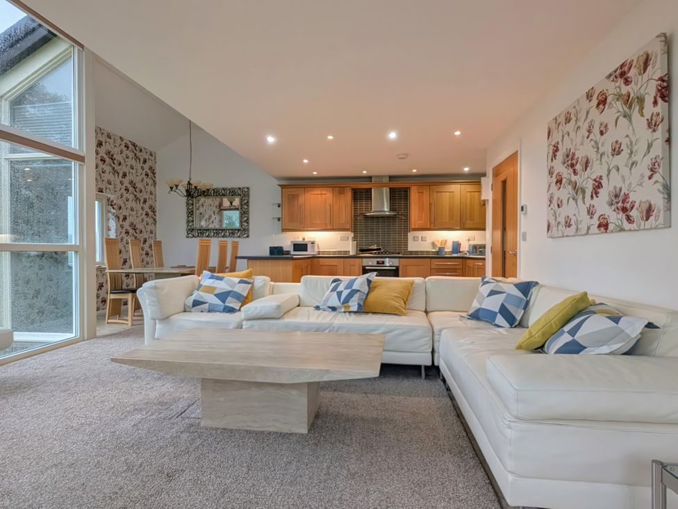 A living room with a sofa and dining area at High View Meadows in Kirkby Lonsdale
