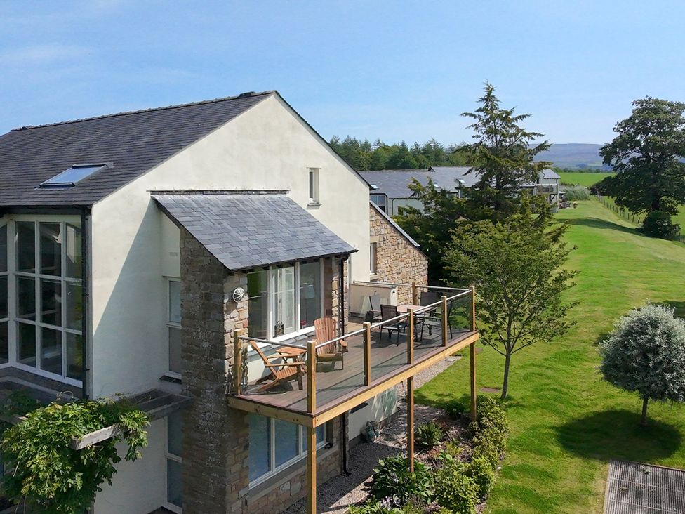 A house with a balcony and surrounding greenery at High View Meadows in Kirkby Lonsdale